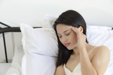 一个头痛的穿着睡衣的东方女人