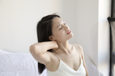 在床上一个颈椎痛的东方女人