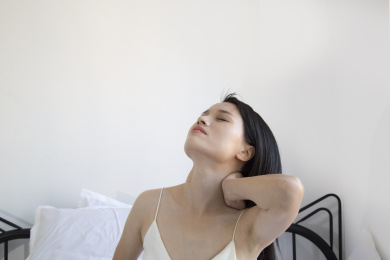 在床上一个颈椎痛的东方女人