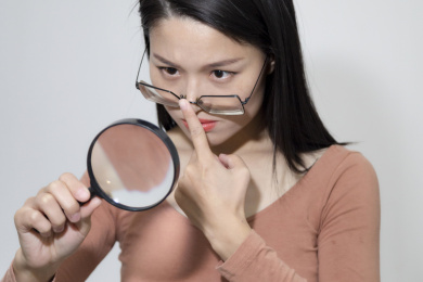 拿着放大镜观察的长头发东方女人