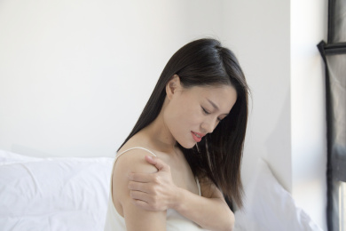 在床上一个颈椎痛的东方女人