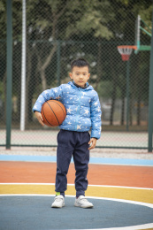 学校操场上打篮球的小男孩