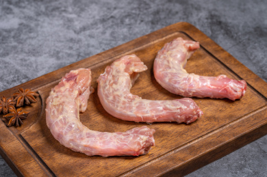 水泥灰背景木砧板上的生鸡脖