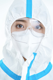 穿白色防护服佩戴护目镜口罩的女性医疗人员
