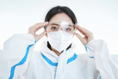 穿白色防护服佩戴护目镜口罩的女性医疗人员