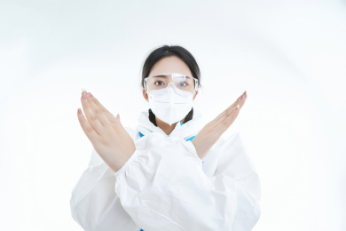 穿白色防护服佩戴护目镜口罩的女性医疗人员