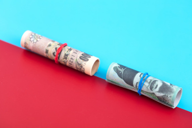 日元和韩元纸币在红蓝分界的背景上