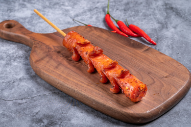 水泥背景上的一根纯肉烤肠