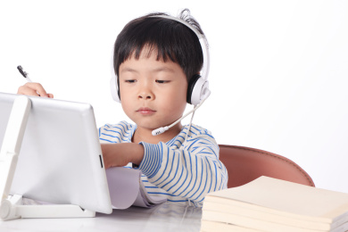 一个男童正在用平板电脑学习