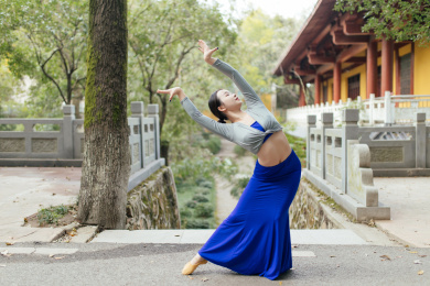 中国美女在户外古建筑前跳中国舞