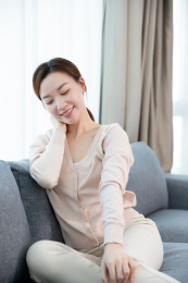 年轻女子沙发上按摩脖子