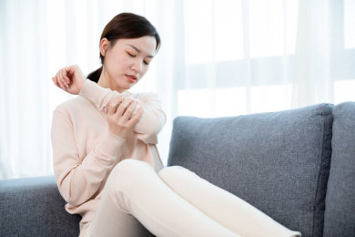 年轻女子手臂疼痛按摩手臂