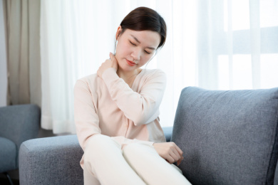 年轻女子沙发上按摩脖子