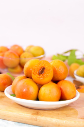 木板上摆放着一盘小红杏