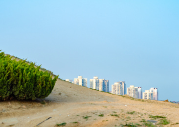 低角度拍摄海岛地面和远处的城市楼房