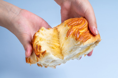 浅蓝色背景前的手撕面包