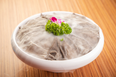 木纹桌上有一盘冰鲜毛肚火锅涮菜盖