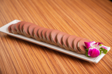 浅色木纹板上放着一盘鸭血