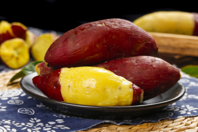 木底蓝布上放着一盘蒸熟的小香薯