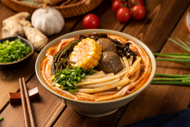 木板背景上满满一碗牛肉汤粉