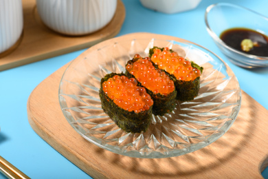 桌面上的盘子里的美味可口的三文鱼子寿司