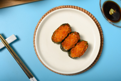 桌面上的盘子里的美味可口的三文鱼子寿司