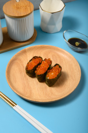 桌面上的盘子里的美味可口的三文鱼子寿司