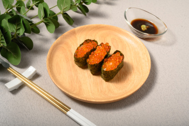 桌面上的盘子里的美味可口的三文鱼子寿司