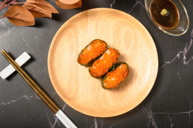 桌面上的盘子里的美味可口的三文鱼子寿司