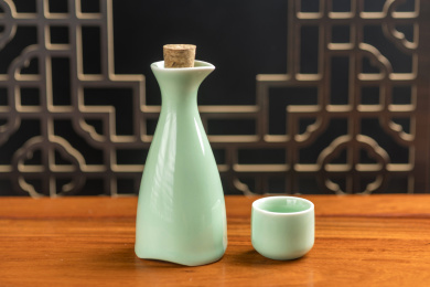酒壶酒杯下酒菜摆放在古窗棂前的木桌面上
