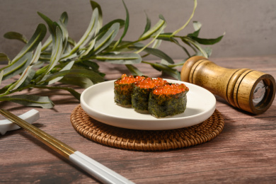 桌面上的盘子里的美味可口的三文鱼子寿司