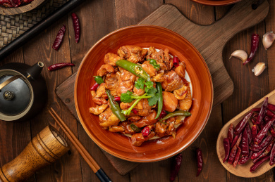 深色木板背景上摆放的辣炒鸡肉