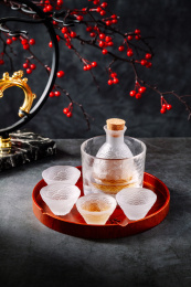 放在暗色底板上的波纹酒壶酒杯酒缸