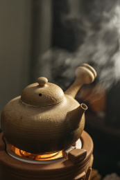 放在火炉上的陶壶正在煮水冒汽