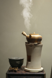 放在火炉上的陶壶正在煮水冒汽