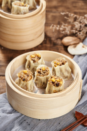 深色背景下放在桌面上的黄豆香菇猪肉烧卖