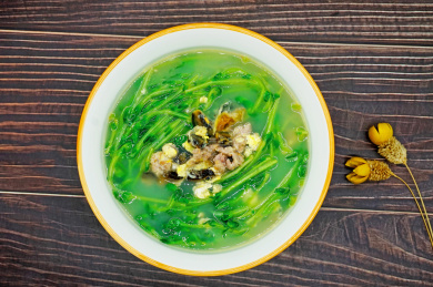 木桌背景一碗上汤豆苗特写