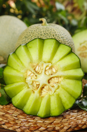 切开的海南网纹蜜瓜放在木底上