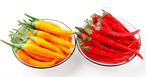 碟子里装着红尖椒和黄尖椒
