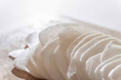 竹制菜板上厚薄一致的白萝卜片