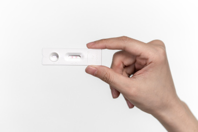 手持结果显示阳性的新冠抗原检测卡