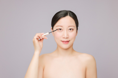 使用睫毛膏 正在化妆的美丽东方女性