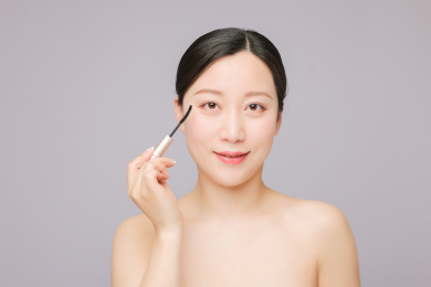 使用睫毛膏 正在化妆的美丽东方女性