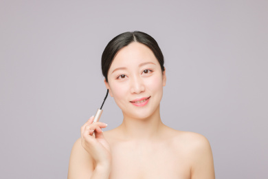 使用睫毛膏 正在化妆的美丽东方女性