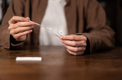 一只手正在将鼻拭子插入提取缓冲液管