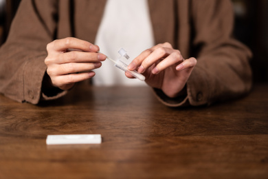 一只手正在将鼻拭子插入提取缓冲液管