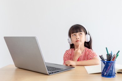 小学生在家使用手提电脑上网课