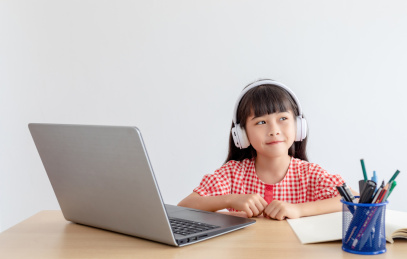 小学生在家使用手提电脑上网课