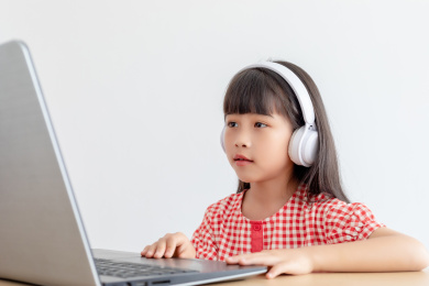 小学生在家使用手提电脑上网课
