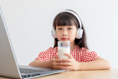小学生在家使用手提电脑上网课